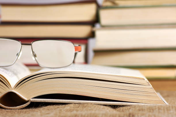 istock An open book with glasses lying on a jute mat with a blurred background 930112166