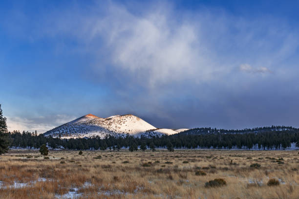 Sunset Crater in Sunset Crater Volcano National Monument catches the late afternoon sun after a winter snow storm.