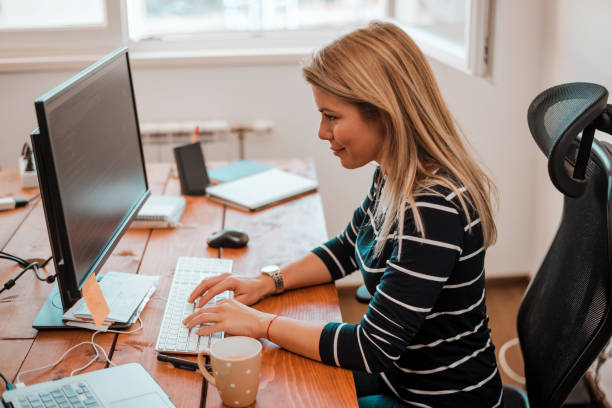 istock Blonde woman working on the computer in the office. 930119096