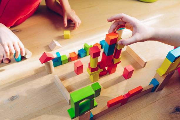 istock sisters have fun - playing with colorful wooden blocks 930124654
