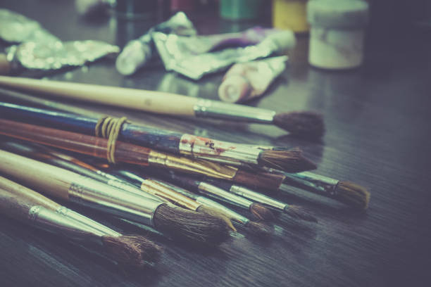 istock Artist paint brushes on wooden background, craft art process 930126232