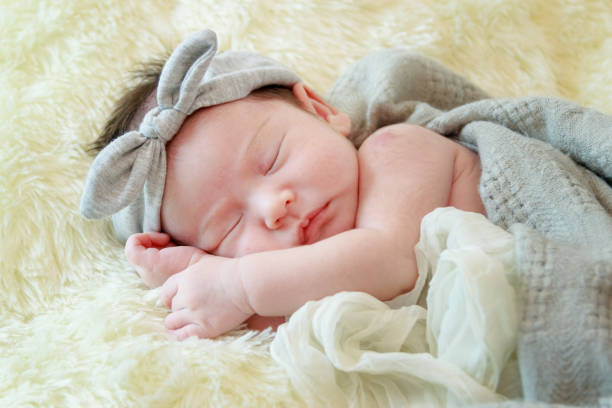 istock Newborn baby girl is sleeping on fur blanket 930130222