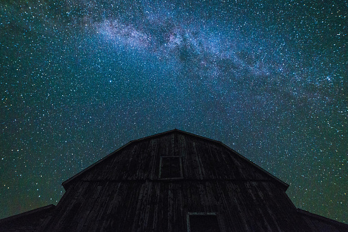 Old Barns and outbuildings with starry sky with clouds and milky way in summer time