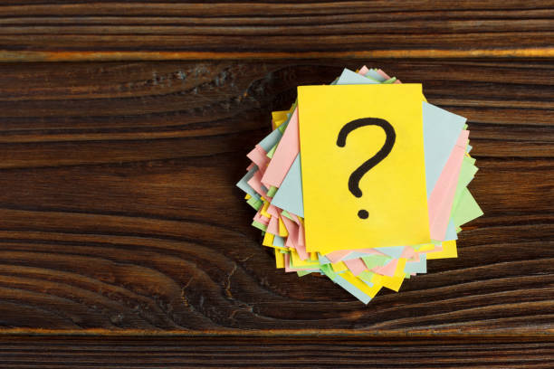 istock Question mark paper heap on wooden table concept for confusion 930155092