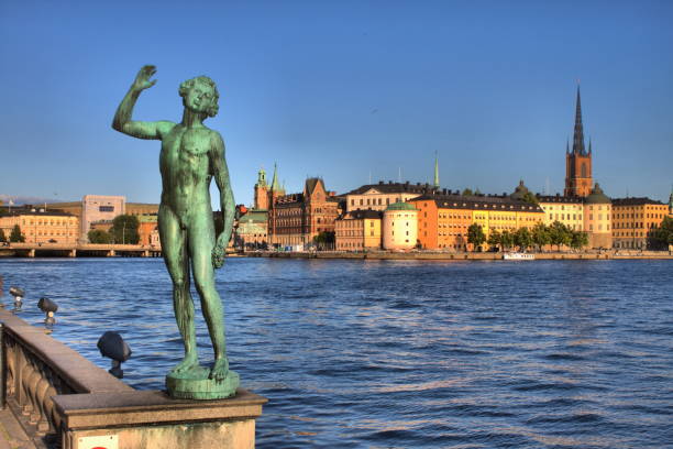 The Dansen (dancer) statue, carved in 1911 by Carl Eldh, on the City Hall square and Gamla Stan skyline, Stockholm, Sweden