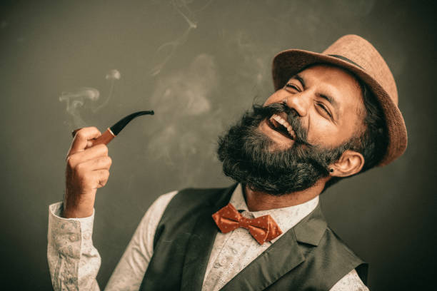 Laughing bearded young man with hat and smoker