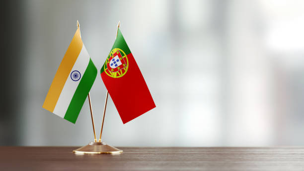 istock Indian And Portuguese Flag Pair On A Desk Over Defocused Background 930170684