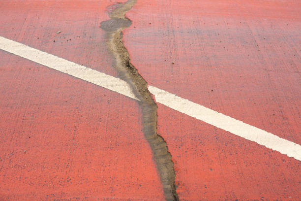 This is a close-up of a weathered and cracked bicycle path. This could be used as a visual to represent urban decay, or as an abstract background for any concept about damage, the old, failure, outdated construction, etc.