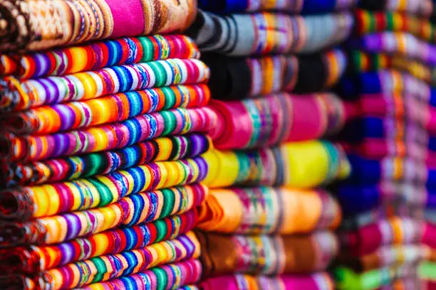 Macro close-up of colorful blankets stacked with Andean designs