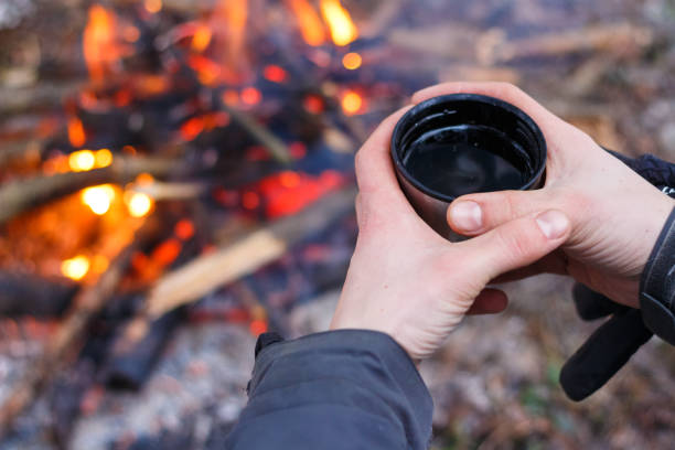 istock Man hands holding cup near the fire 930193534