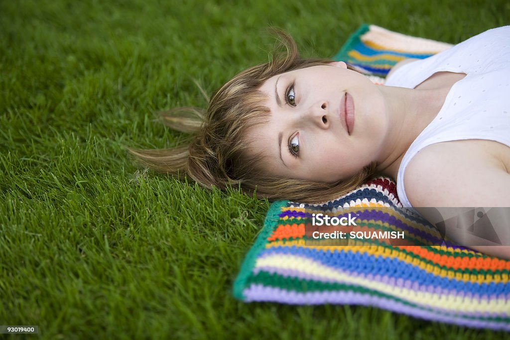 Jolie jeune femme se dresse sur une couverture dans l'herbe - Photo de Adolescence libre de droits