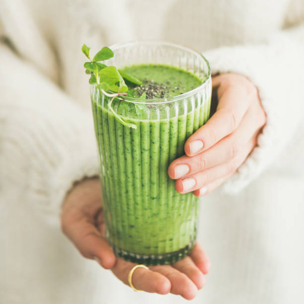 istock Matcha smoothie with chia seeds in female hands, square crop 930233676