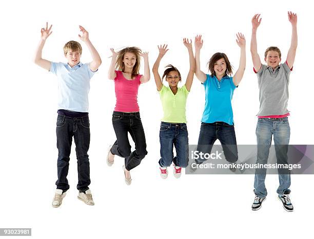 Gruppo Di Amici Adolescenti Saltando In Studio - Fotografie stock e altre immagini di Saltare - Saltare, 14-15 anni, A mezz'aria