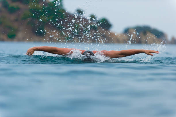istock young sporting man swims in the sea dolphin style. 930265174