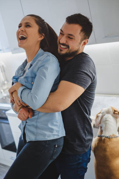 istock Couple laughing in the kitchen while he is holding her 930265368