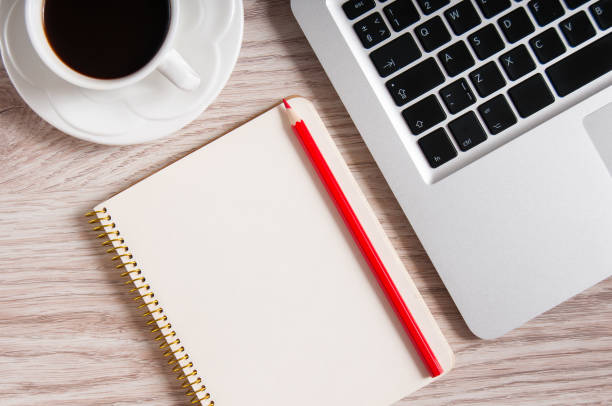 istock Notepad, laptop and coffee cup on wood table 930271030