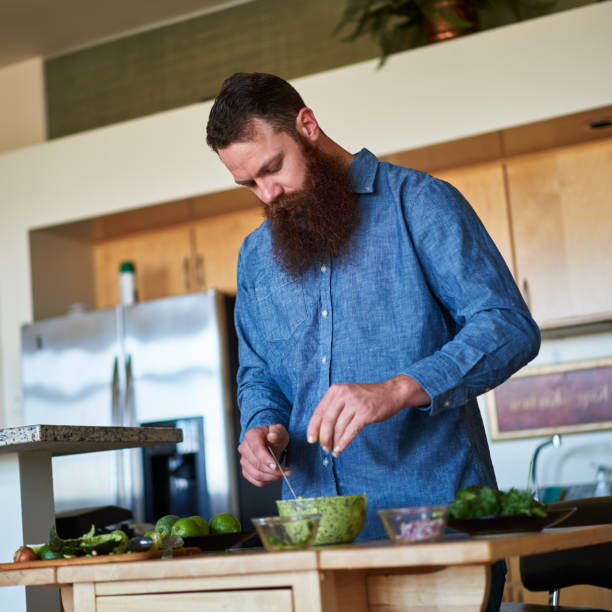 istock bearded guy squeezing lime juice into bowl of guacamole 930273820