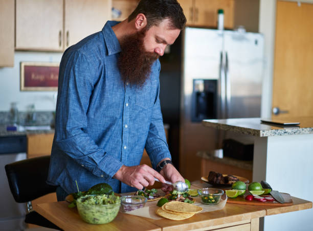 istock adding guacamole to homemade tacos in kitchen 930273890