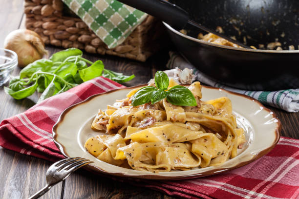 皿に生ハムとチーズのソースのパッパルデッレ - pappardelle ストックフォトと画像