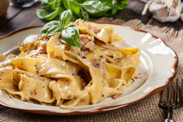 istock Pappardelle pasta with prosciutto and cheese sauce on a plate 930286688
