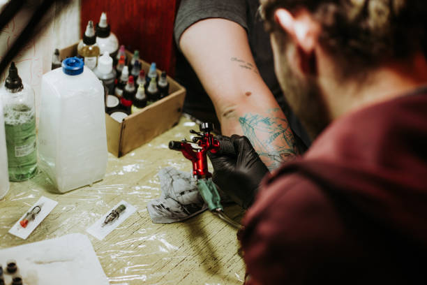 istock Artist making tattoo on customer's hand 930287162