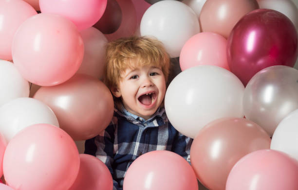 Child screams in balloons. Cute crying at party. Beautiful background with pink balls and sad kid. Children hysteria or laughing, smile baby open mouth. Happy childhood. Birthday gifts and discounts Child screams in balloons. Cute crying at party. Beautiful background with pink balls and sad kid. Children hysteria or laughing, smile baby open mouth. Happy childhood. Birthday gifts and discounts child laughing hysterically stock pictures, royalty-free photos & images