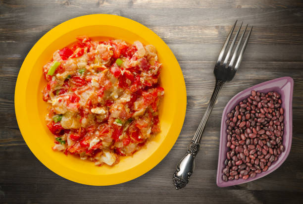 istock Stewed tomatoes with onions in a plate on a wooden background 930309330