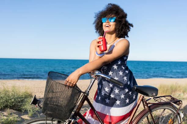 istock Smiling african woman drinking red cocktail on beach 930309416