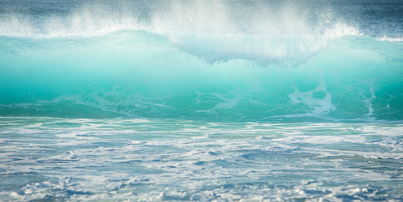 Turquoise perfect waves in ocean. Breaking wave ideal for surfing