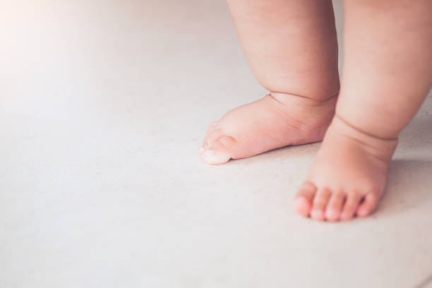 istock Small baby feet doing the first step on the floor 930367406