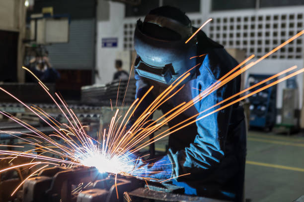 istock Industrial worker is welding with protective mask in car factory 930367752