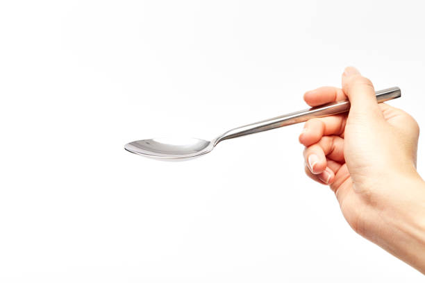 istock woman's right hand holds a spoon on a white background. 930368860