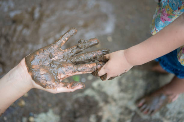 istock Muddy parent and child hands 930371220