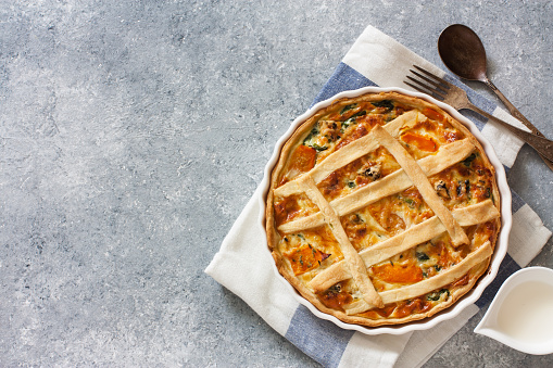 Pumpkin and spinach pie ( quiche)  over blue stone background. Top view. Copy space