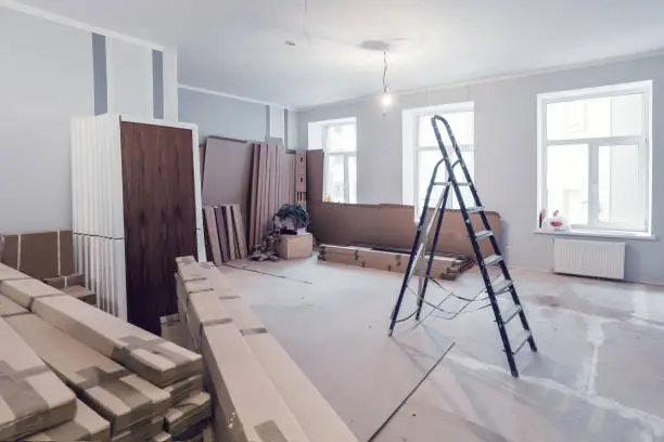 Photo of Interior of apartment  during construction, remodeling, renovation, extension, restoration and reconstruction - ladder and construction materials in the room