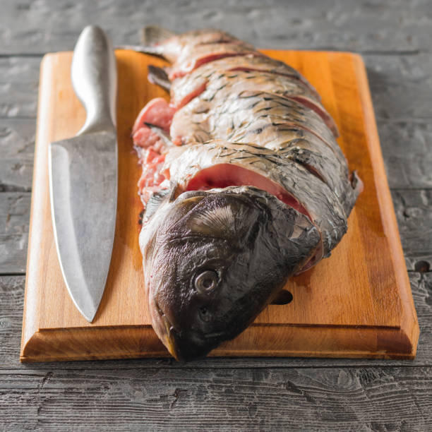 istock Freshly cut cut carp on a cutting Board with a knife. 930378590