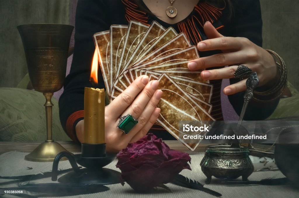 Tarot cards on fortune teller desk table. Future reading concept. Tarot cards on fortune teller desk table. Future reading. Woman fortune teller holding and hands a deck of tarot cards. Fortune Teller Stock Photo