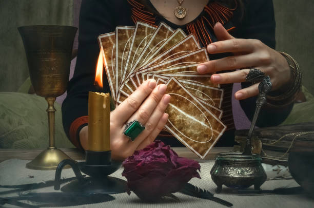 Tarot cards on fortune teller desk table. Future reading concept. Tarot cards on fortune teller desk table. Future reading. Woman fortune teller holding and hands a deck of tarot cards. fortune teller photos stock pictures, royalty-free photos & images