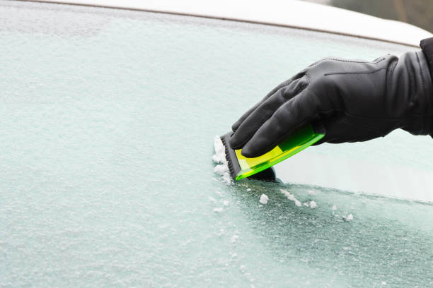 istock Hand in glove scraping ice from car windscreen 930393536