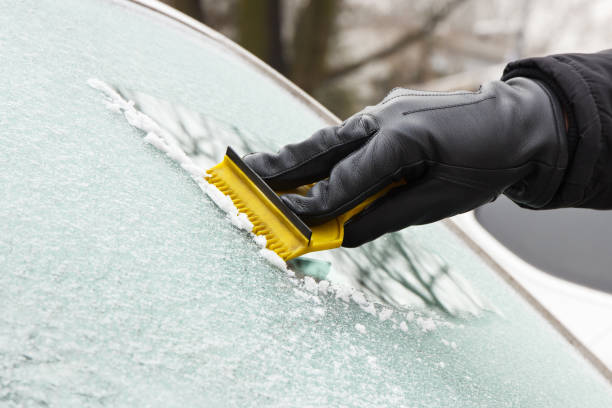istock Hand in glove scraping ice from car windscreen 930393570