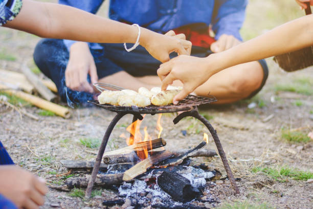 istock Teacher and students camping outdoor, outdoor activity, learning natural, camping around camp fire, banana grill 930393876