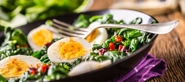 istock Spinach Salad. Fresh spinach salad with eggs chili pepper and sweet cranberries 930401088