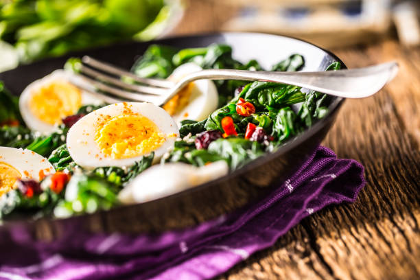 istock Spinach Salad. Fresh spinach salad with eggs chili pepper and sweet cranberries 930401114