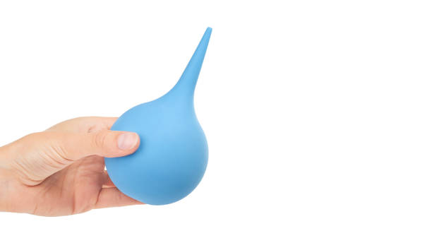 istock female hand holding blue enema ot syringe bulb. Isolated on white background. copy space, template 930406336