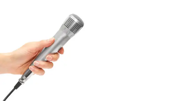 Photo of female hand holding a stereo microphone to record a song or karaoke. Isolated on white background. copy space, template.
