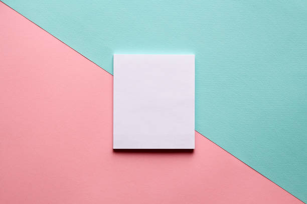 Abstract geometric background in pastel trend colors with notebook. Abstract geometric diagonal watercolor paper background in soft pastel pink and blue trend colors with white notebook on it. two objects photos stock pictures, royalty-free photos & images
