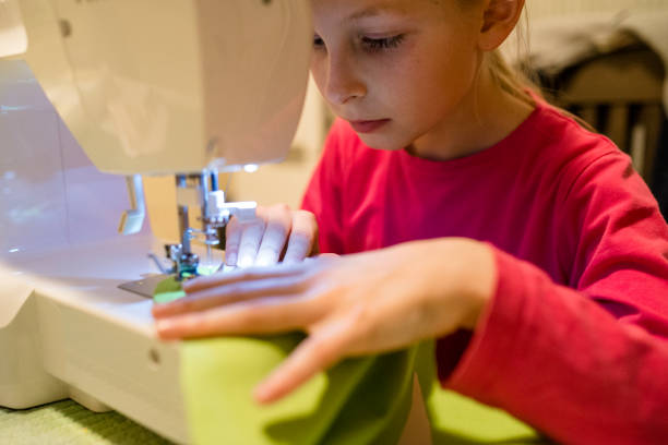 istock Girl learns to sew on an electric sewing machine 930428980
