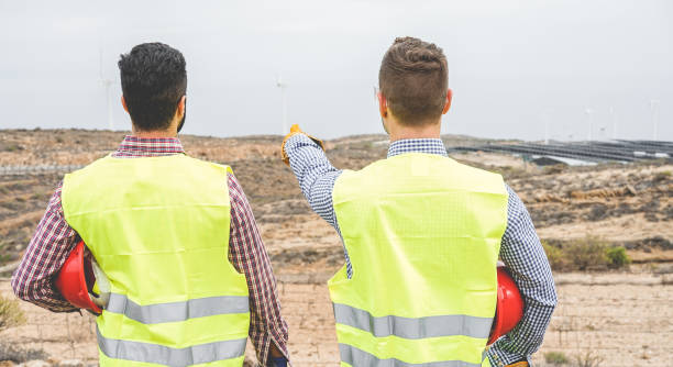 Builders pointing new area for building wind farm and photovoltaic plant site - Happy workers planning new projects - Dealing, real estate, engineer, industrial concept - Focus on right man head constructores señalando nueva área para la construcción de parque eólico y el sitio de la planta fotovoltaica - trabajadores felizes planeando nuevos proyectos - tratar, inmobiliario, ingeniero, industrial concepto - centran en cabeza del hombre adecuado