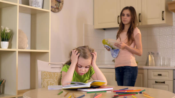 istock Mom washing dishes watching as daughter doing her homework with difficulty 930437014
