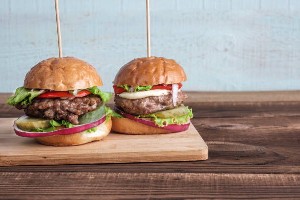 istock A two burgers on a wooden plate. 930440142